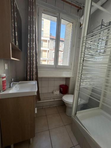 a bathroom with a sink and a toilet and a window at myappart - colombes in Colombes