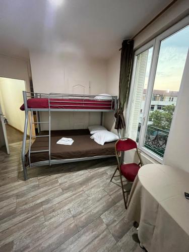 a small room with a bunk bed and a chair at myappart - colombes in Colombes