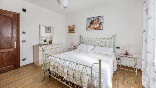 a bedroom with a white bed and a wooden floor at Casa Il Pino in Cavriglia