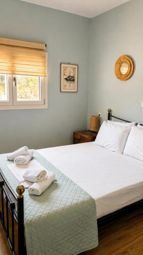 a bedroom with a large white bed with towels on it at Seaside Serenity Kefalos in Kefalos