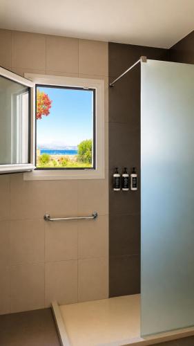a bathroom with a shower with a window at Seaside Serenity Kefalos in Kefalos