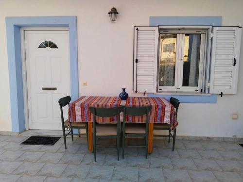 a table with chairs and a vase on top of it at Christos House in Zárakes