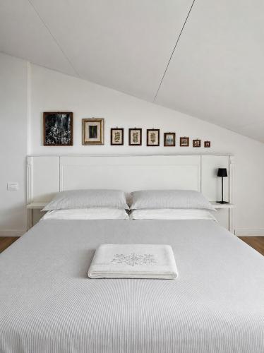 a white bed with a white blanket on it at Casa Olgaluna - Art Home in La Spezia