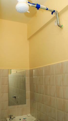 a bathroom with a shower and a sink and a light at Magik Haven Studios Nyeri in Nyeri