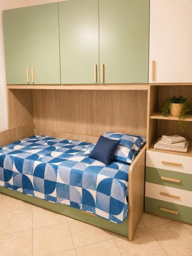 a bedroom with a bed with blue and white sheets at Optima Casa Vacanze II in Telese