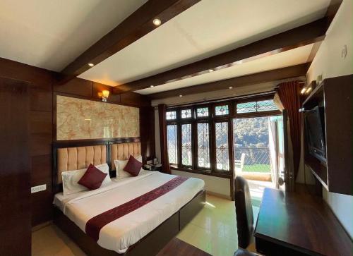 a bedroom with a large bed and a television at The Lake BnB in Nainital
