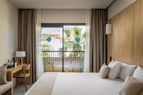 a hotel room with a bed and a large window at Hotel Delfín 4 Sup in Tossa de Mar