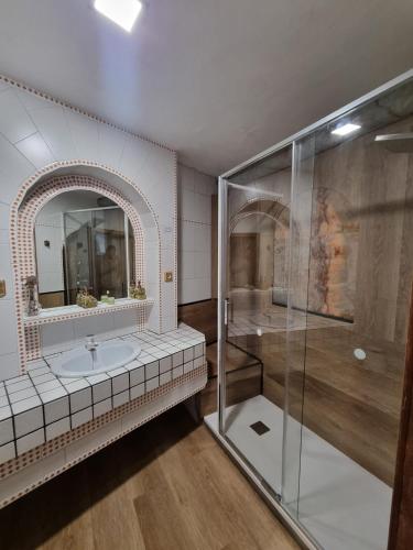 a bathroom with a shower and a sink and a mirror at Casa Turqueta in Benaocaz