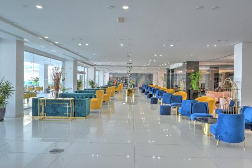 a lobby with a row of blue and yellow chairs at King Evelthon Beach Hotel & Resort in Paphos
