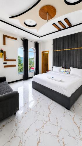 a large bedroom with a large bed and a couch at Nathia Gali Top Resort in Nathia Gali