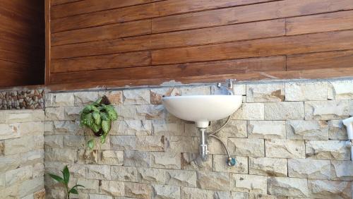 a bathroom with a sink on a stone wall at FURUSATO BUNGALOW Gili Gede in Gili Gede