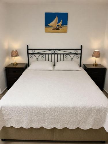 a bedroom with a large white bed with two lamps at Villa Tego in Çeşme