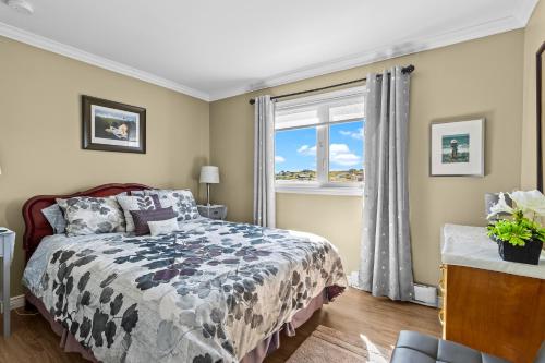 a bedroom with a bed and a window at Westward Oceanfront Sunsets over Trinity Bay in Hearts Delight