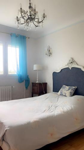 a bedroom with a large white bed with a blue headboard at Gîte Aux Anges 51 in Thiéblemont-Farémont