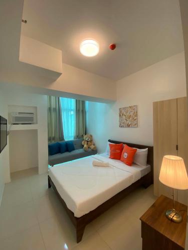 a bedroom with a large bed and a couch at MyHappyPlace Elements in Manila