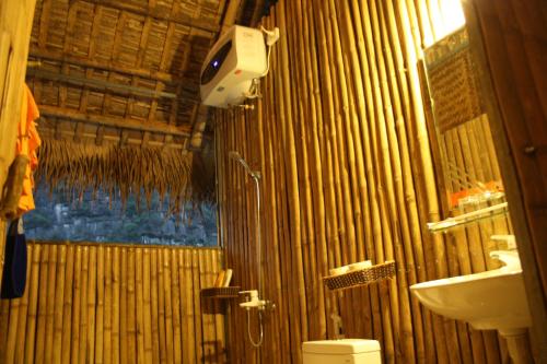 a bamboo bathroom with a toilet and a sink at Ninh Binh Valley Homestay in Ninh Binh
