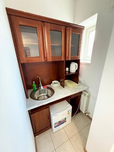 a small kitchen with a sink and a microwave at Mini Hotel "Arystan" в самом центре столицы in Astana