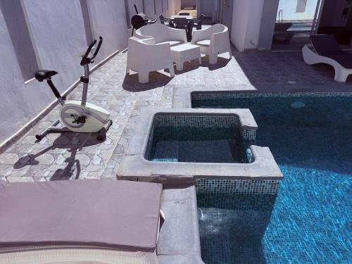 a swimming pool with a table and chairs and a vacuum at Villa Sofia Djerba in Awlād ‘Umar