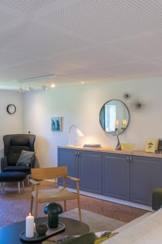 a living room with a table and a mirror at Sjælegård Countryside Lodge in Allinge
