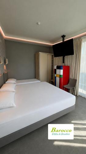 a bedroom with a large white bed in a room at Barocco Villa & Studios in Potamiá
