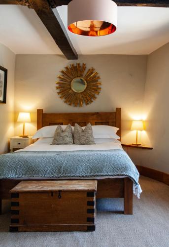 a bedroom with a large bed and a mirror at The Ebrington Arms in Chipping Campden