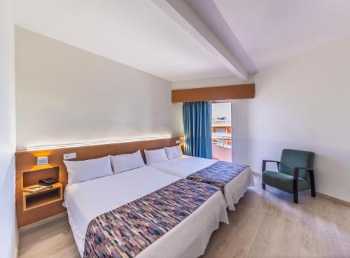 a bedroom with a large bed and a chair at Hotel Alone in Cala de Finestrat