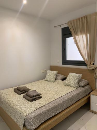 a bedroom with a bed with pillows and a window at Basia in Torrevieja
