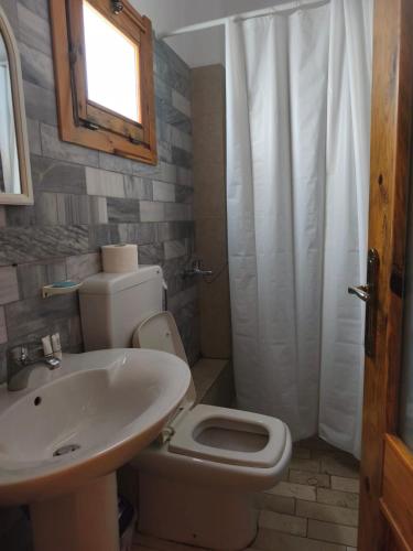 a bathroom with a white toilet and a sink at Guesthouse Vila Druri Dhermi in Dhërmi