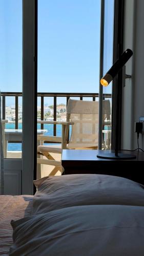 a bedroom with a bed and a view of a balcony at Hotel Lito in Tinos