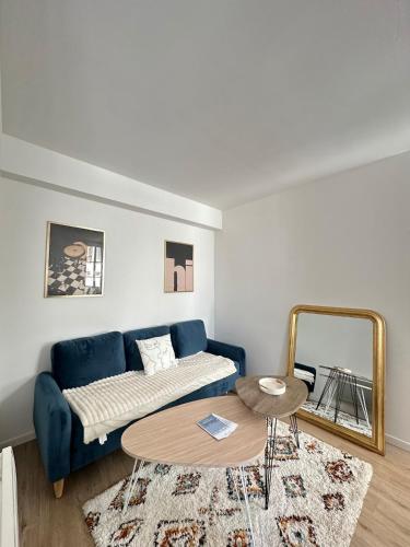 a living room with a blue couch and a table at Halles in Les Sables-d'Olonne