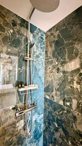 a bathroom with a shower with a blue wall at Hotel Lito in Tinos