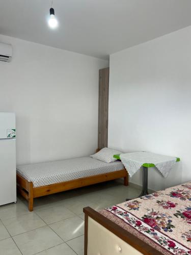 a room with two beds and a table in it at Grandma's in Sarandë