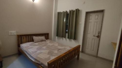 a bedroom with a bed in a room with a door at SRUSHTI The Peace Home HOME STAY in Kolhapur