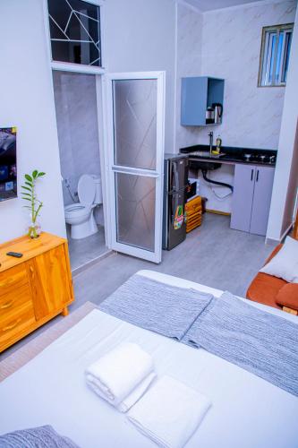 a room with a bed and a desk with a computer at ExtraMile Apartments - Cozy Studio in Dodoma