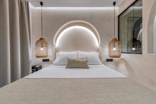 ein Schlafzimmer mit einem weißen Bett mit einem Bogen darüber in der Unterkunft néreya luxury rooms in Charaki
