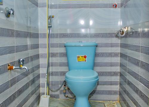 a blue toilet in a bathroom with a shower at Rimayalounge in Embu
