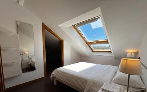 a bedroom with a bed with a window and a mirror at Playa America 4F by YBH in Nigrán