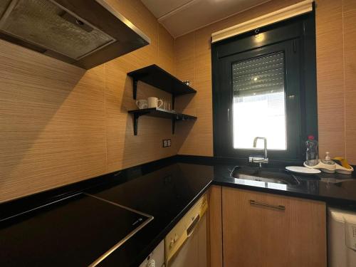 a kitchen with a sink and a window at Playa America 4F by YBH in Nigrán