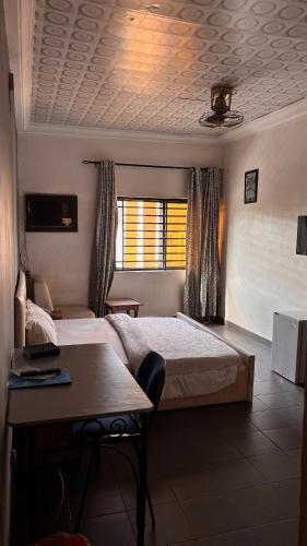 a bedroom with a bed and a desk and a window at Diamond Hotel Lagos in Lagos