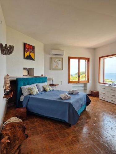 a bedroom with a blue bed and two windows at Villa Blu Sorrento seaview pool terrace and Jacuzzi in Sorrento