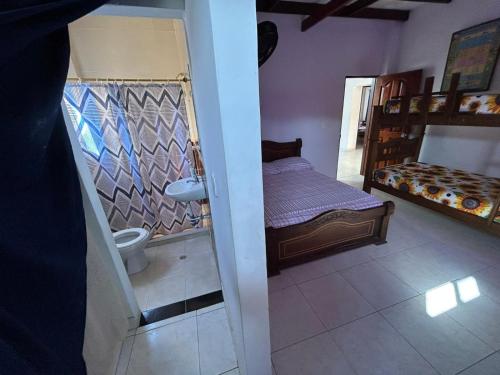 a small bedroom with a bed and a bathroom at Casa de Campo Palmarito in Tubará