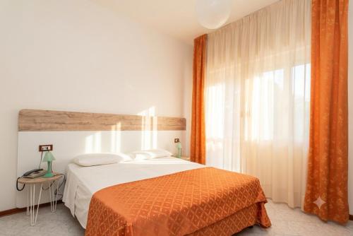a bedroom with a bed and a large window at Hotel Di Giovanni in Bibione