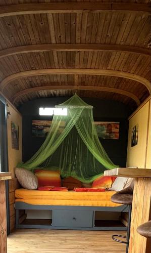 a bed with a net on top of it at Down under in France in Lormes