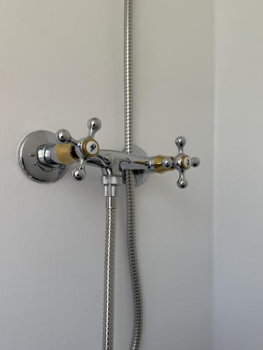 a shower with a hose and a shower head at Velling Koller Hotel og Camping in Bryrup