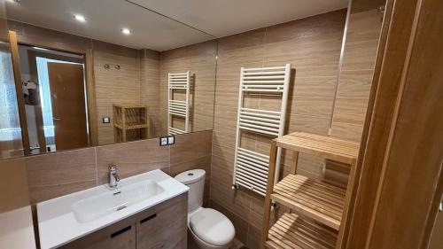 a bathroom with a sink and a toilet and a mirror at Playa America 1E by YBH in Nigrán