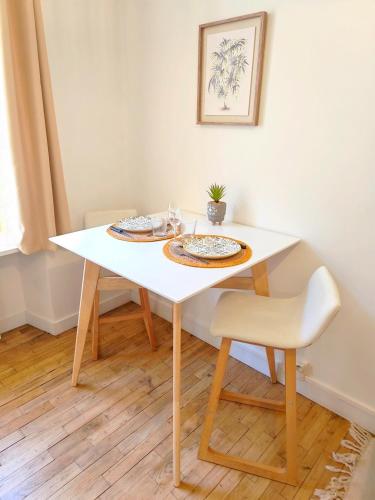 a white dining room table with two plates on it at Le Byzantin - T2 Hyper centre in Pontivy