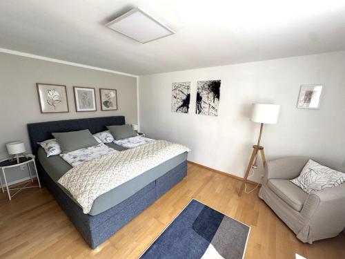 a bedroom with a bed and a chair in it at InNatura Velden in Velden am Wörthersee