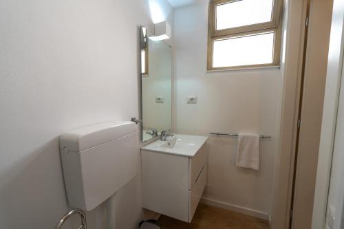 ein weißes Badezimmer mit Waschbecken und Spiegel in der Unterkunft Breva e Tivano in Rezzonico