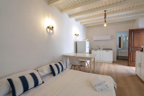 ein weißes Schlafzimmer mit Bett und Küche in der Unterkunft Breva e Tivano in Rezzonico