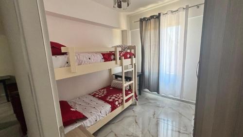 ein Zimmer mit zwei Etagenbetten und einem Fenster in der Unterkunft Lin Luli in (( Shën Ded Gjoni ))